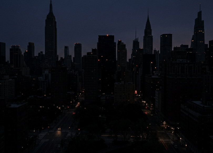 New York City skyline at night with illuminated windows and streets